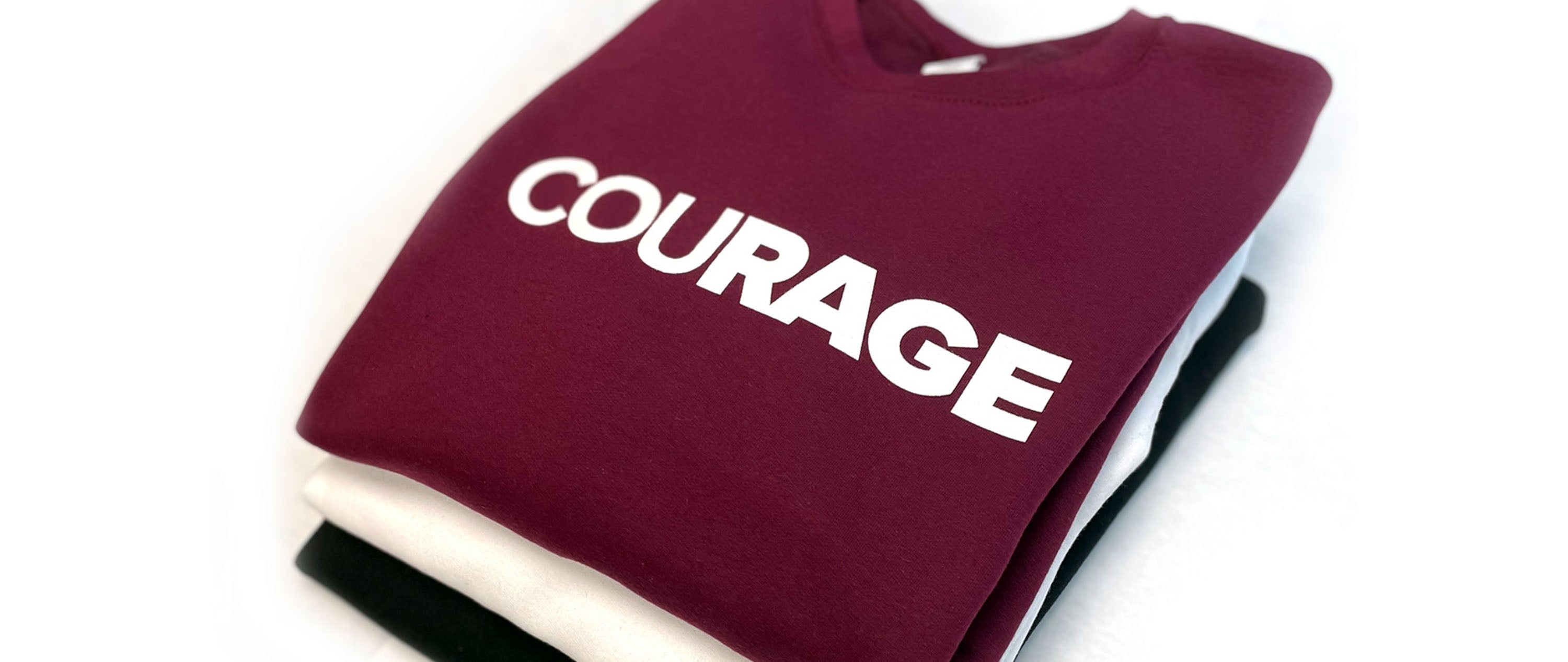 Stack of sweatshirts with Courage branding